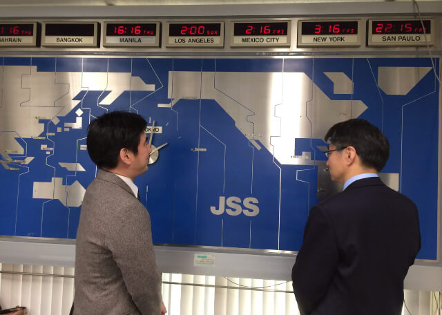 世界地図の前で話し合う2人